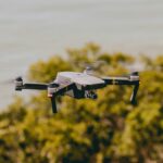 Aerial view of a drone flying over lush greenery and water, capturing stunning outdoor scenes.
